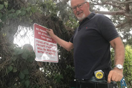 Ryavec Posts Signs on Post Office Fence